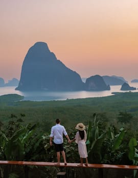 A couple of men and woman watching the sunrise at Sametnangshe viewpoint in Phangnga Bay with mangrove forest in the Andaman Sea, Sametnangshe mountain Phangnga, Thailand