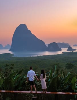 A couple of men and woman watching the sunrise at Sametnangshe viewpoint Phangnga Bay with mangrove forest in the Andaman Sea, Sametnangshe travel destination in Phangnga, Thailand