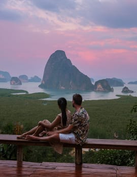 A couple of men and woman watching the sunrise at Sametnangshe viewpoint Phangnga Bay with mangrove forest in the Andaman Sea, Sametnangshe travel destination in Phangnga, Thailand