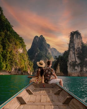 A couple of men and women in front of a longtail boat in Khao Sok Thailand, Scenic mountains on the lake in Khao Sok National Park South East Asia at sunset