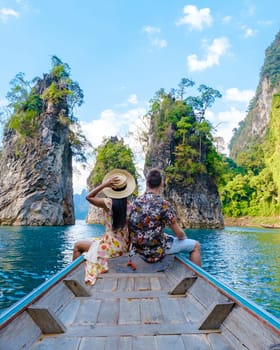 A couple of men and women in front of a longtail boat in Khao Sok Thailand, Scenic mountains on the lake in Khao Sok National Park South East Asia, men and woman on a boat trip