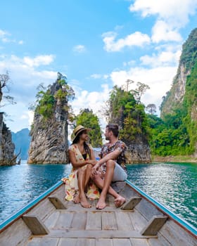 A couple of men and women in front of a longtail boat in Khao Sok Thailand, Scenic mountains on the lake in Khao Sok National Park South East Asia, men and woman on a boat trip