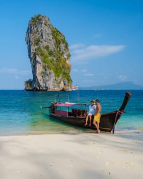 Koh Poda Beach Krabi Thailand, the tropical beach of Koh Poda Island Krabi, a couple of men in swim short and women in bikini walking on the beach on a sunny day,