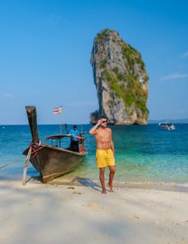 young men at Koh Poda Beach Krabi Thailand, the tropical beach of Koh Poda Island Krabi, a man in swim short walking on the beach,