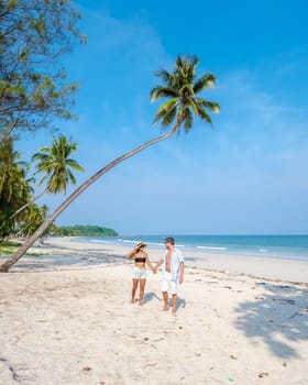 couple on vacation in Thailand Chumphon province walking at a white tropical beach with palm trees, Wua Laen beach Chumphon Thailand, palm tree hanging over the beach