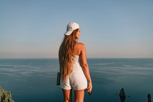 Portrait of a happy woman in a cap with long hair against the sea.