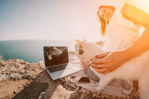 Woman sea laptop. Business woman in yellow hat working on laptop by sea. Close up on hands of pretty lady typing on computer outdoors summer day. Freelance, digital nomad, travel and holidays concept.