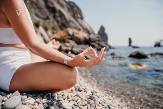 Woman sea yoga. Back view of free calm happy satisfied woman with long hair standing on top rock with yoga position against of sky by the sea. Healthy lifestyle outdoors in nature, fitness concept.