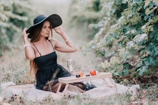 Picnic and wine tasting at sunset in the hills of Italy, Tuscany. Vineyards and open nature in the summer. Romantic dinner, fruit and wine.