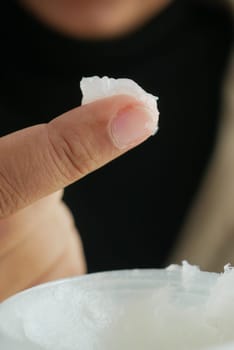 woman using petroleum jelly onto skin at home close up..