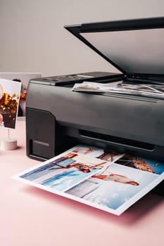 Modern laser printer printing color photos of women close up on desk