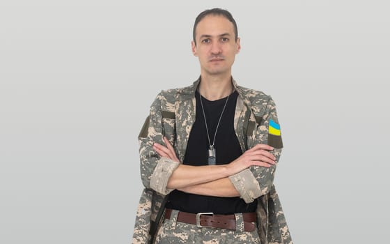 Ukrainian soldier wearing military uniform with flag and chevron depicting trident - Ukrainian national symbol flag.
