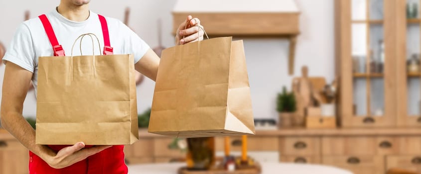 box with fast food being carried by delivery man in uniform for one of clients.