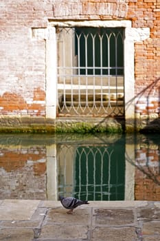 Italy. Close-ups of building facades in Venice. A look at the old scratched arch in the wall near the water in the canal