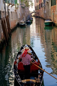 Sunny channel in Venice with boats parked around