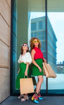 Two young beautiful girls walking the streets of the city with shopping bag. shopping woman fashion