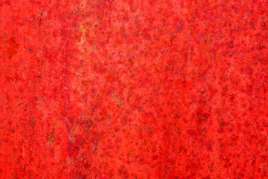 Red metal surface with spots creating textured wall background