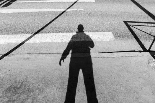 Shadowy Figure Strolling Down an Urban Street. Black and white photo. Selective focus