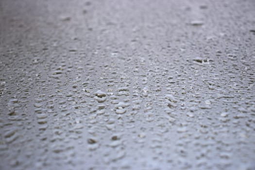 Close-up view on water drops on window in rain. Drops of rain on the glass concept photo. Front view photography with blurred background. High quality picture