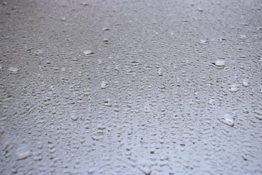 Close-up view on water drops on window in rain. Drops of rain on the glass concept photo. Front view photography with blurred background. High quality picture