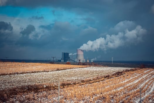 Panoramic view of nuclear power plant with wheat field Nuclear power plant cooling towers, big chimneys concept photo. Two possibility for production of electric energy