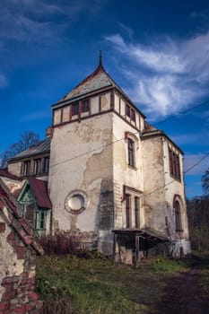 Facade of the old castle concept photo. European towers. Architectural detail of damage building. Old doors, windows, balconies. Ukrainian moldings