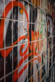 Colorful graffiti paintings on old brick wall concept photo. Street art composition with parts of unwritten letters. High quality picture for wallpaper, travel blog.