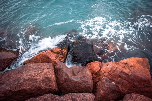 Mediterranean winter stormy seaside. Close up water with stones on the beach concept photo. Underwater rock. The view from the top, nautical background. High quality picture for wallpaper