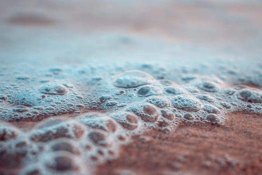 Close up sea water with little bubbles photo. Surface with selective focus in the foreground and blurry background. Mediterranean sea, nautical background. High quality picture for wallpaper, travel blog