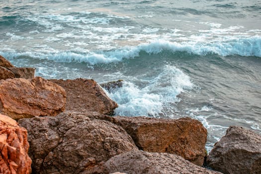 Mediterranean winter stormy seaside. Close up water with stones on the beach concept photo. Underwater rock. The view from the top, nautical background. High quality picture for wallpaper