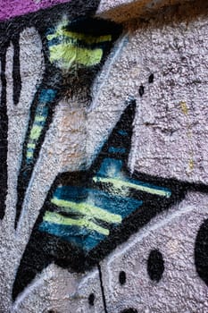 Abstract colorful fragment of graffiti paintings on wall. Street art composition with parts of unwritten letters. High quality picture for wallpaper, travel blog.