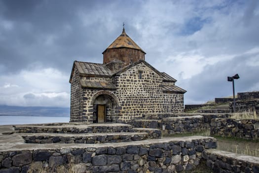 Monastery complex under dramatic spring sky photo. Ancient church near Lake Sevan concept photo. High quality picture for wallpaper