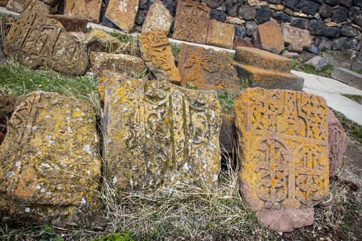 Stone cross with yellow lichen cover the rough stone concept photo. Historical tombs and head stones. Rocks full of the moss texture in nature for wallpaper.