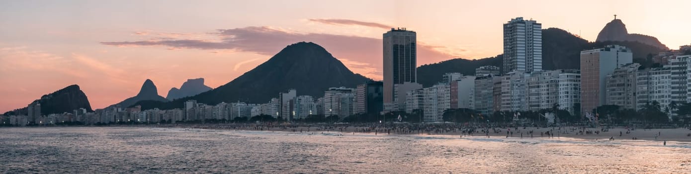 Dusk at Copacabana Beach with golden hues, Christ the Redeemer and mountain silhouettes