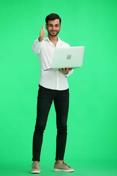 man on a green background. uses a computer, and show like sign.