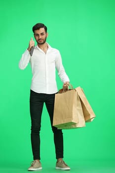 Man on a green background with shoppers show thumb up.