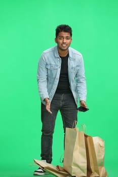 Man on a green background with shoppers.