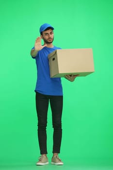 A man on a green background with box. In profile.