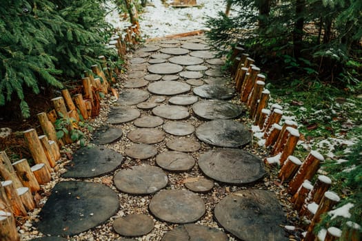 Creative idea for garden paths made of wood, log cabin. Winter nature. High quality photo