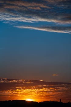 Stunning sunset with the sun setting behind clouds.