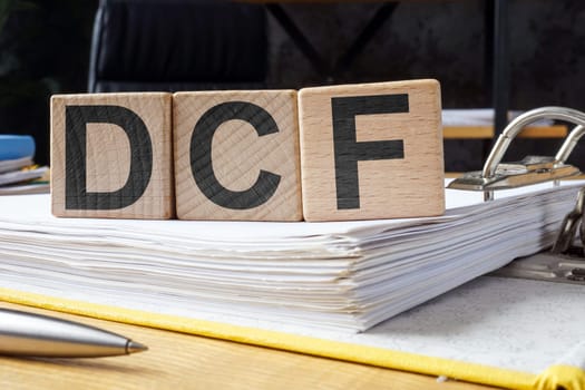 Open folder and cubes with letters DCF Discounted Cash Flow.