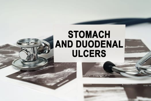 Medical concept. On the ultrasound pictures there is a stethoscope and a business card with the inscription - Stomach and duodenal ulcers