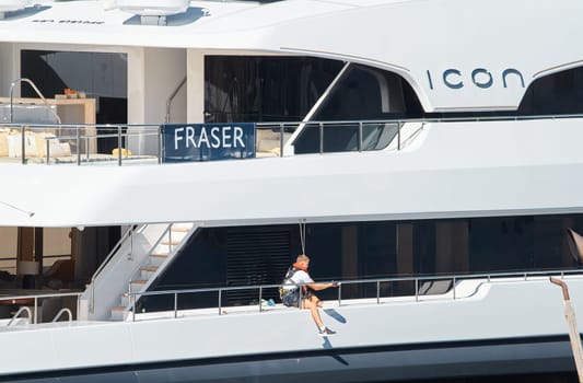 Monaco, Monte Carlo, 28 September 2022 - a member of the team washes the yacht and prepares the boat for the reception of guests at the famous motorboat exhibition in the principality, yacht brokers. High quality photo