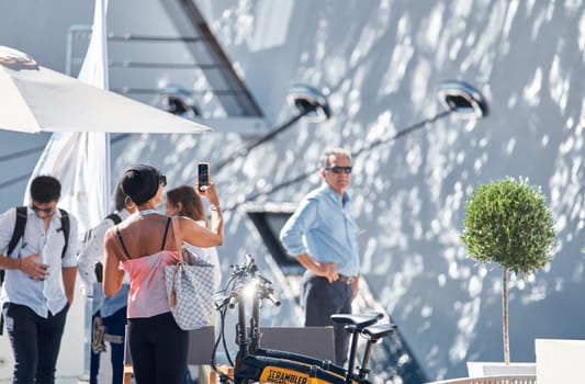 Monaco, Monte Carlo, 28 September 2022 - Invited wealthy clients inspect megayachts at the largest fair exhibition in the world yacht show MYS, port Hercules, yacht brokers, sunny weather. High quality photo