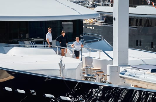 Monaco, Monte Carlo, 28 September 2022 - Invited wealthy clients inspect megayachts at the largest fair exhibition in the world yacht show MYS, port Hercules, yacht brokers, sunny weather. High quality photo