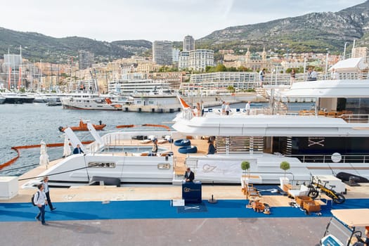 Monaco, Monte Carlo, 29 September 2022 - Invited wealthy clients inspect mega yachts at the largest fair exhibition in the world yacht show MYS, port Hercules, yacht brokers, sunny weather. High quality photo