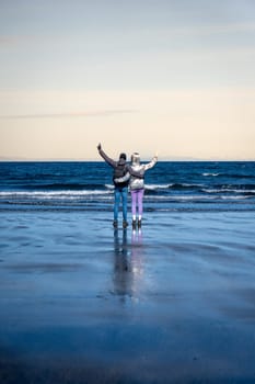 Couple from behind looking at the sea in winter