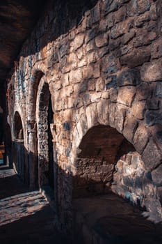 Old brick wall niches in church photo. Black door leading in ancient church photography. Beige brick textured wall. Sant Miquel del Fai monastery. High quality picture for wallpaper, article