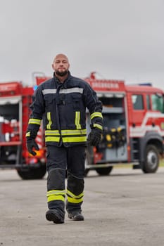 A symbolically brave firefighter strides forward with unwavering courage, epitomizing dedication and leadership, while behind him, a modern firetruck stands ready for firefighting actions, capturing the essence of heroism and preparedness in the face of emergency.