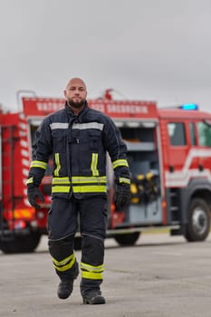 A symbolically brave firefighter strides forward with unwavering courage, epitomizing dedication and leadership, while behind him, a modern firetruck stands ready for firefighting actions, capturing the essence of heroism and preparedness in the face of emergency.